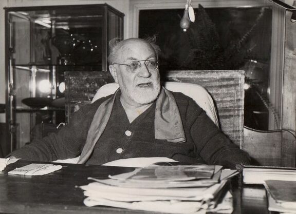 Henri Matisse sitzend hinter Schreibtisch